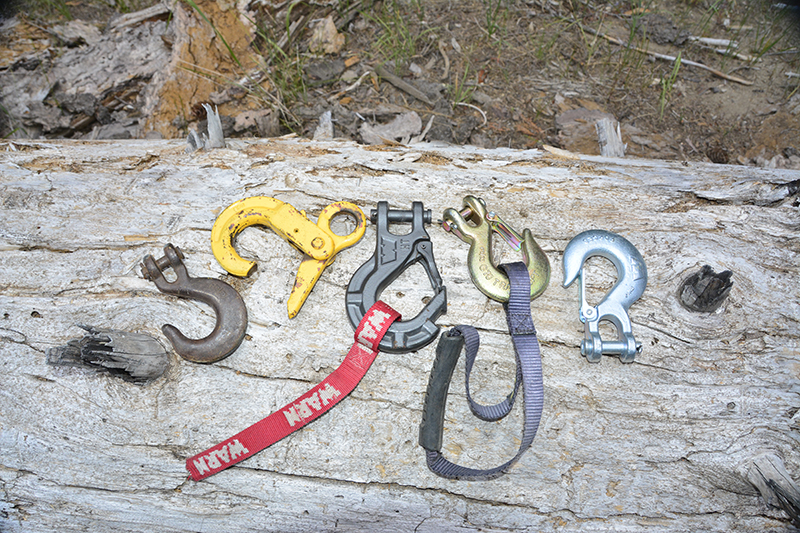 This photo shows several winch hooks. Left to right – Stock clevis sling hook, positive locking or safety hook (the best), WARN’s Epic throat latch clevis sling hook, two standard throat latch clevis sling hooks.
